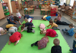 Dzieci leżą skulone na dywanie